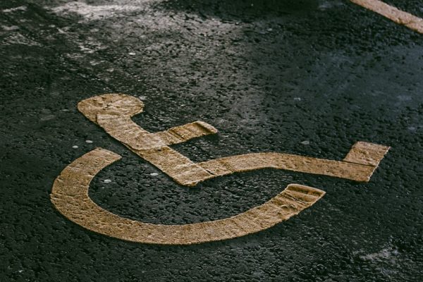 a handicapped sign painted on the pavement of a parking lot